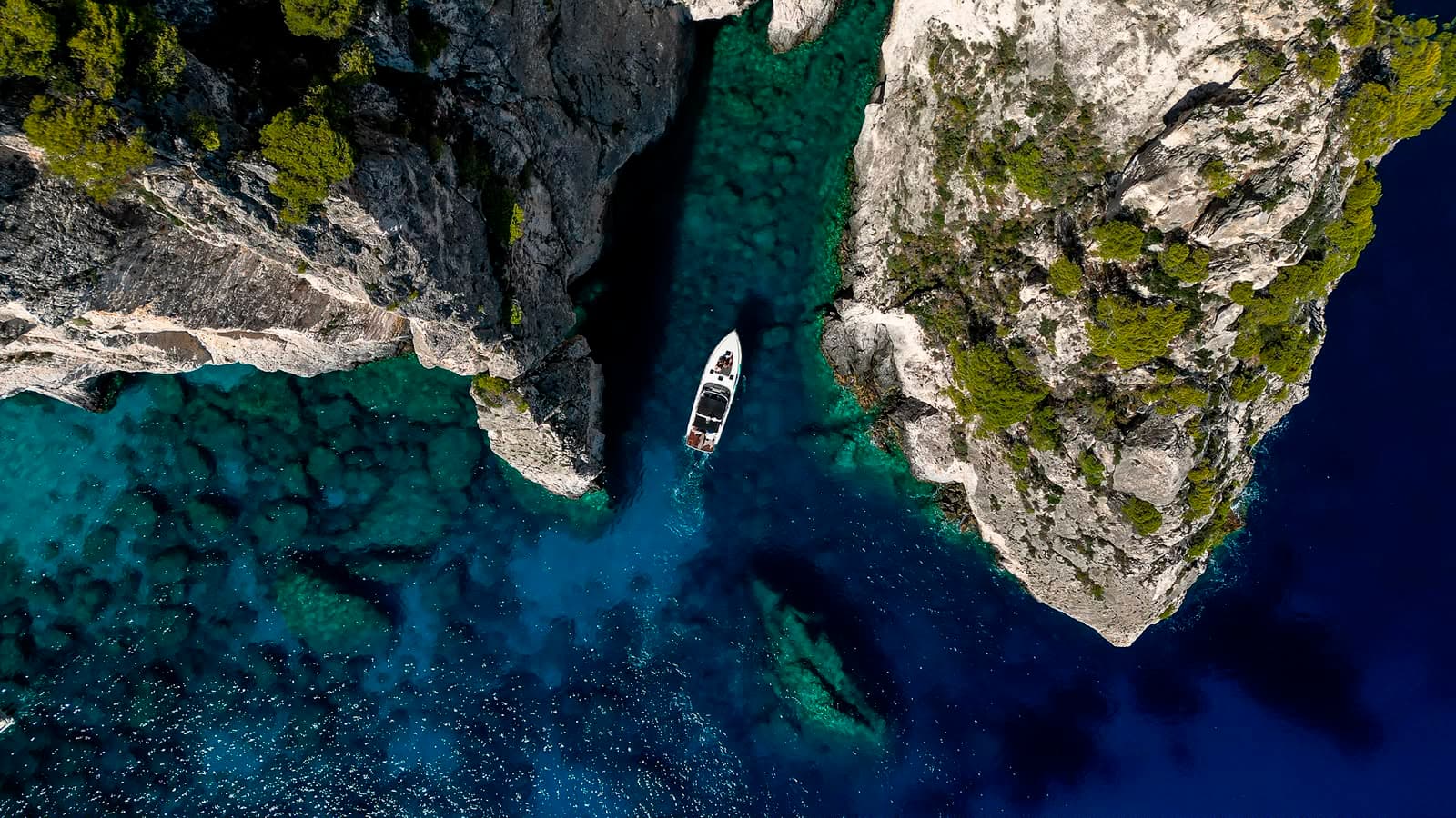 Aerial view of a private boat in turquoise waters between Zakynthos cliffs